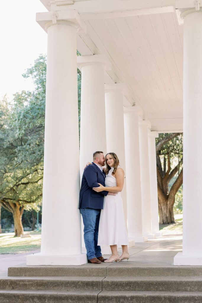 Couple standing in front of Arlington Hall with white columns in Dallas