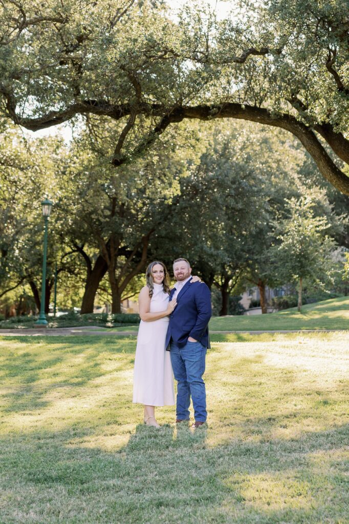 Couple standing under the trees at Arlington Hall with sunlight filtering through