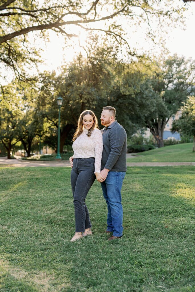 Ryan and Madeline in casual outfits posing under the trees at Arlington Hall