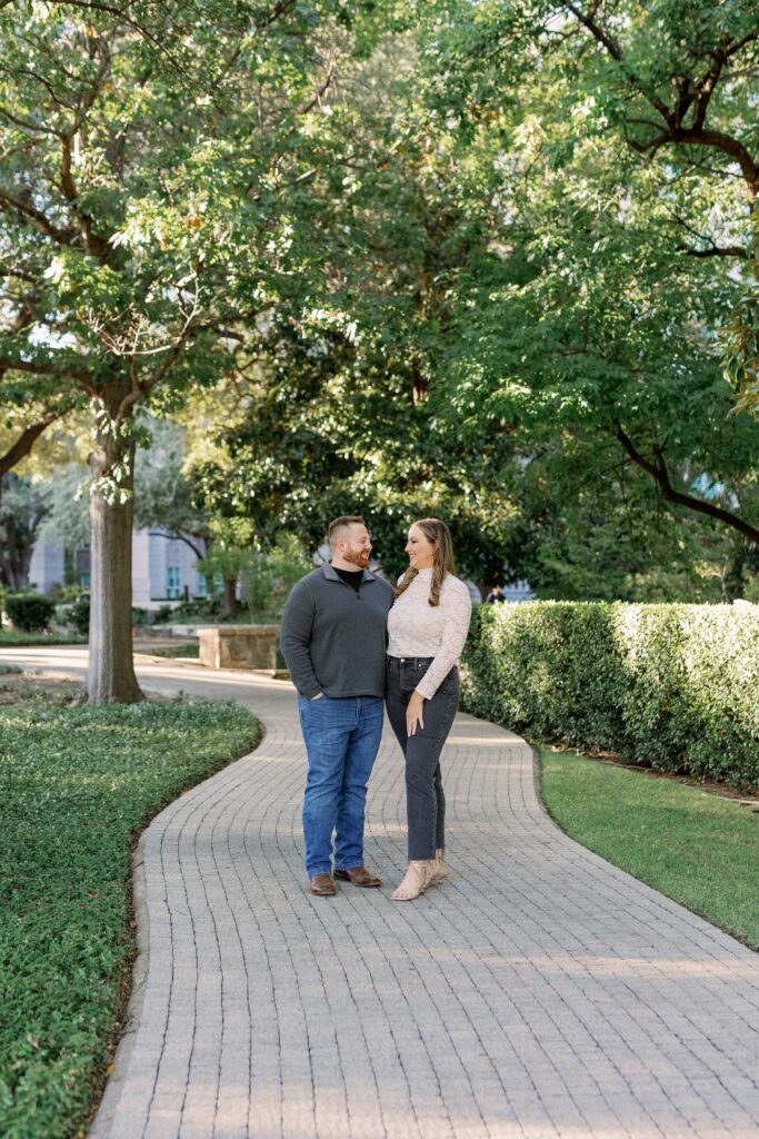 Couple walking along the path at Turtle Creek with greenery behind them