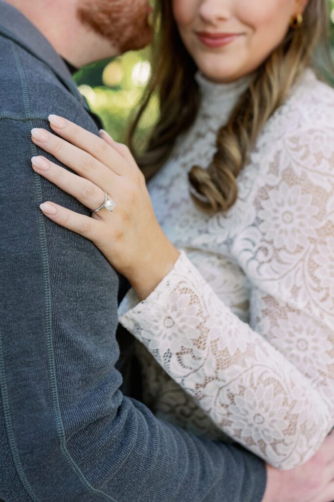 Close up portrait showing Madeline’s lace top and engagement ring